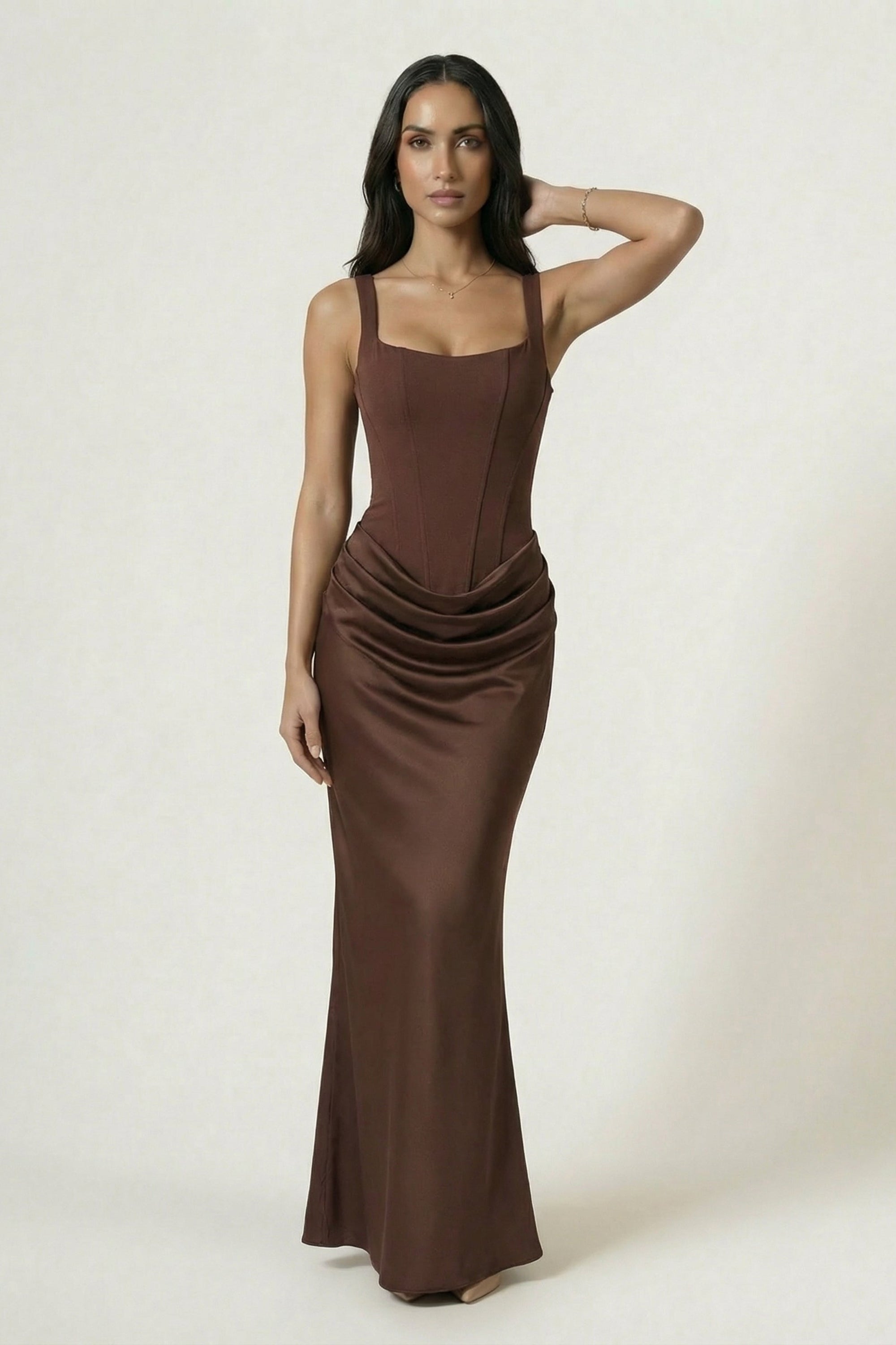 Woman wearing a brown evening gown against a white background